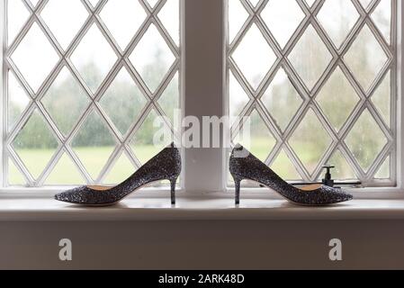 Brautschuhe auf der Fensterdichtung mit Hintergrundbeleuchtung Stockfoto