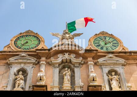 Italien, Sizilien, Provinz Trapani, Trapani. Uhrturm mit italienischer Flagge im Stadtzentrum von Trapani. Stockfoto