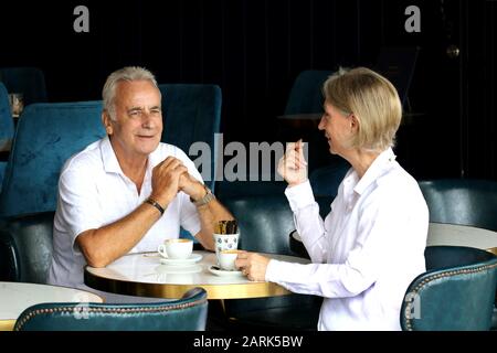 Reifes Ehepaar: Ein reifes Ehepaar in einem Café, das Kaffee zusammen hat und spricht, in Farbe erschossen. Stockfoto