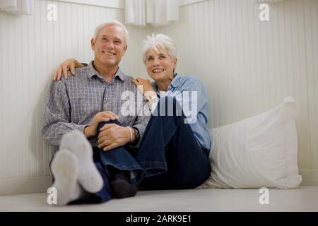 Älteres Paar sitzt auf Kopfkissen auf dem Boden Stockfoto