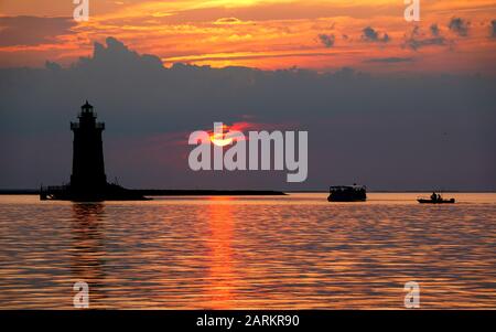 Silhouette des Leuchtturms und der Boote während des Sonnenuntergangs im Cape Henlopen State Park, Lewes, Delaware, U.S.A Stockfoto