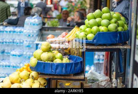 Äpfel und Birnen auf der Greengrocer-Theke. Bank auf dem Straßenbelag. Stockfoto