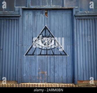 Alle, die Augengraffiti an alter Lagertür sehen, verschwörungstheoretische Geheimgesellschaftskonzept Stockfoto