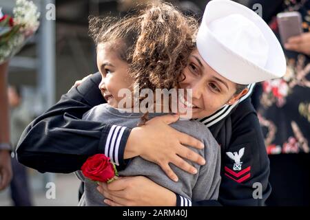 191127-N-PX867-1599 SAN DIEGO (NOV. 27, 2019) Boatswains Mate 2nd Class Silvia Simuel-Leon, die dem amphibischen Angriffsschiff USS Boxer (LHD 4) zugeordnet ist, hält ihre Tochter erstmals während einer Heimkehr auf dem Marinestützpunkt San Diego. Boxer, Teil der Boxer Amphibious Ready Group (ARG), kehrt nach einem 7-monatigen Einsatz im 5. Und 7. Flottenbereich in seinen Heimathafen San Diego zurück. (USA Navy Foto von Mass Communication Specialist 3rd Class Justin Whitley) Stockfoto