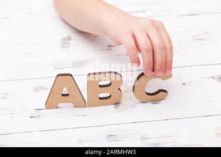 Die Hände des Kindes, die ABC-Buchstaben halten. Bildungskonzept. Stockfoto