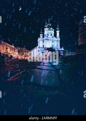 Andreaskirche in Kiew mit Schneeflocken und Nachtbeleuchtung, Ukraine Stockfoto