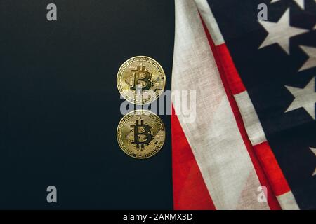 Bitcoin Cryptocurrency Münzen neben amerikanischem Flaggenhintergrund. Stockfoto