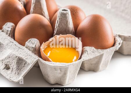Frische Hühnereier in der Pfirsich mit zerbrochenem Ei. Stockfoto