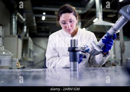 Labortechnikerin in blauen Gummihandschuhen mit 3D-Drucker auf verschwommenem Hintergrund, neue Technologien Stockfoto