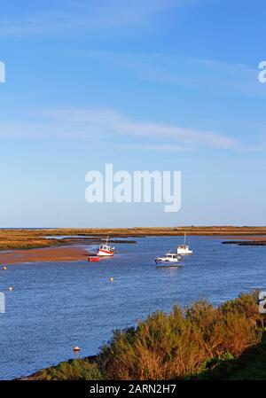 Eine Gruppe kleiner Fischerboote, die in Overy Creek an der Norfolkküste in Burnham Overy Staithe, Norfolk, England, Großbritannien, Europa ankerten. Stockfoto