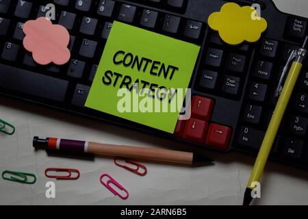 Inhaltsstrategie Schreiben Sie auf eine Haftnotiz, die auf dem Schreibtisch isoliert ist. Stockfoto