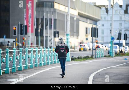 Brighton UK 29. Januar 2020 - Ein Fahrer mit elektrischem Roller an der Küste von Brighton an einem kühlen, hellen Morgen als wärmeres, aber feuchtes Wetter wird erwartet, dass er in den nächsten Tagen über das Land zurückkehren wird. Kredit: Simon Dack / Alamy Live News Stockfoto