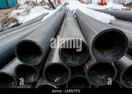 Stapel von Kunststoffrohren auf der Baustelle einsatzbereit. Stockfoto