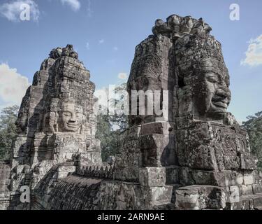 Siem Reap Temple Site. Auf der oberen Terrasse des Bayon-Tempels befinden sich die berühmten Gesichtstürme. Vier lächelnde Gesichter werden in diesem Bild aufgenommen. Stockfoto