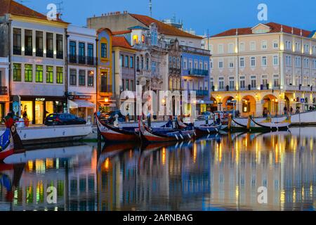 Moliceiros günstig entlang des Hauptkanals bei Sonnenuntergang. Aveiro, Venedig von Portugal, Beira Litoral, Portugal Stockfoto