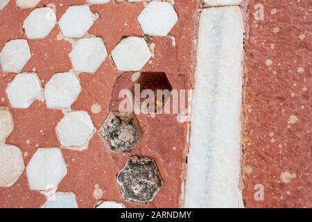 Detail der Wanddekoration Muster aus weißem Marmor und rotem Sandstein mit Biene auf dem Grab von Akbar The Great in Agra am übergiebelten Tag Stockfoto