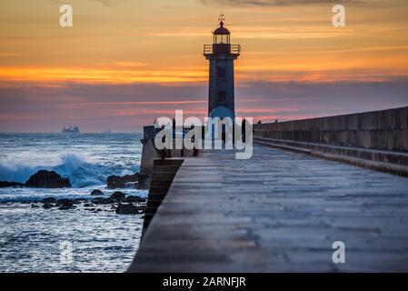 Sonnenuntergang über dem Atlantik. Ansicht mit Felgueiras Leuchtturm (Farol de Felgueiras) auf einem Wellenbrecher von Foz Douro Bezirk von Porto Stadt, zweiten großen Stockfoto