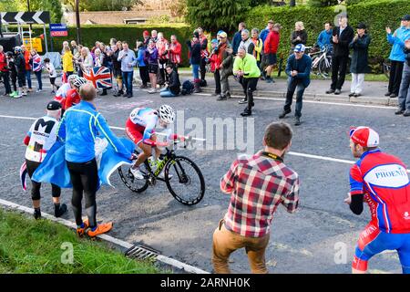 3 Frauen im Straßenrennen, die bergauf fahren, im Radrennen gegeneinander antreten, von Anhängern bejubelt und geklungen werden - die Weltmeisterschaften der ORKSen, Harrogate, GB, Großbritannien. Stockfoto