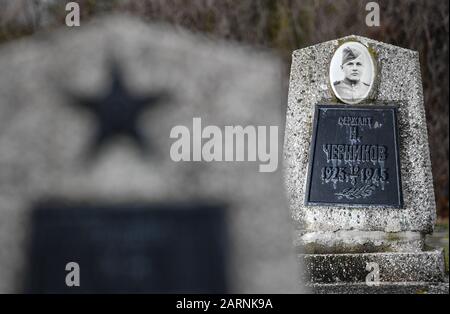 Seelow, Deutschland. Januar 2020. Auf seinem Grabstein auf dem Gelände der Seelower Höhen Gedenkstätte ist ein Porträt eines sowjetischen Soldaten zu sehen. Kurz vor Ende des Zweiten Weltkriegs starben in der Schlacht auf den Seelower Höhen östlich von Berlin Zehntausende Soldaten und Zivilisten in der größten Schlacht des Zweiten Weltkriegs auf deutschem Boden. Credit: Patrick Pleul / dpa-Zentralbild / ZB / dpa / Alamy Live News Stockfoto