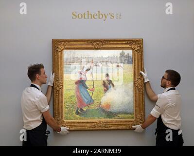 Sotheby's Mitarbeiter hängen Gelee Blanche, Jeune Paysanne Faisant Du Feu von Camille Pissarro während eines Fotorufs für Höhepunkte von Sotheby's bevorstehender impressionistischer, Moderner und surrealistischer Kunstverkäufe, darunter Werke von Van Gogh, Miro und Monet, bei Sotheby's in London. Stockfoto