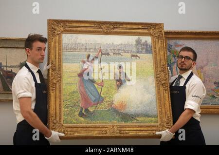 Sotheby's Mitarbeiter hängen Gelee Blanche, Jeune Paysanne Faisant Du Feu von Camille Pissarro während eines Fotorufs für Höhepunkte von Sotheby's bevorstehender impressionistischer, Moderner und surrealistischer Kunstverkäufe, darunter Werke von Van Gogh, Miro und Monet, bei Sotheby's in London. Stockfoto