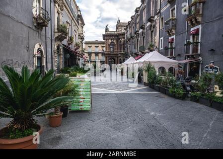 Restaurants auf über Michele Rapisardi Straße in der Stadt Catania, Ostseite der Insel Sizilien, Italien. Opernhaus Teatro Massimo Bellini auf Hintergrund Stockfoto