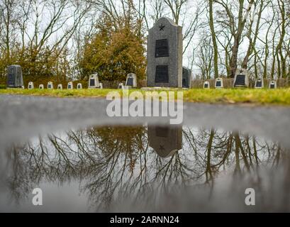 Seelow, Deutschland. Januar 2020. Grab- und Gedenksteine spiegeln sich in einer Pfütze auf dem Gelände der Seelower Höhen-Gedenkstätte wider. Kurz vor Ende des Zweiten Weltkriegs starben in der Schlacht auf den Seelower Höhen östlich von Berlin Zehntausende Soldaten und Zivilisten in der größten Schlacht des Zweiten Weltkriegs auf deutschem Boden. Credit: Patrick Pleul / dpa-Zentralbild / ZB / dpa / Alamy Live News Stockfoto