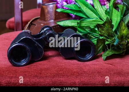 Schwarzes Fernglas auf dem Grund der Blumen Stockfoto