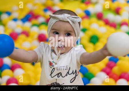 Ein süßes kleines Mädchen, das auf dem Indoor-Spielplatz in einem Einkaufszentrum spielt. Stockfoto