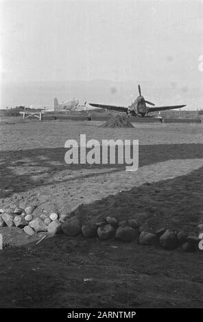 Flughafen Calibanteng am Semarang. Erdarbeiten. Eine Curtiss P40 Kampfflugzeugplane. Im Hintergrund ein Dakota-Datum: April 1947 Ort: Indonesien, Niederländisch-Ostindien Stockfoto