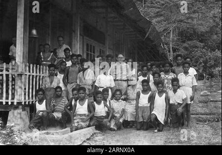 Jungle Reverend J. Eygendaal, aus der MIEI-Internat, zusammen mit dem intelligenten jungen papuas, der auf einem Gruppenfoto abgebildet ist Datum: Oktober 1948 Ort: Indonesien, Niederländische Ostindien Stockfoto