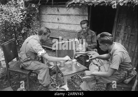 Reinigungsaktionen W-Brigade Reinigungsaktionen in Pekalongan: Auch im Rest bleiben die niederländischen Soldaten verschiedener Landesnorm brüderlich zusammen. Der Soldat Rinus van Geldert aus Ophemert (bei Tiel) und die KNIL-Soldaten P. Sastro aus Pekalongan und Piet aus Bandjaran (bei Tegal) nehmen einen Löffel aus der CAN-Notaufnahme: Dezember 1948 Ort: Indonesien, Java, Niederländische Ostindien Stockfoto