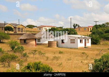 Wohnhäuser im Dorf an der Straße zwischen St. Lucia und Imfolozi-Hluhluwe National Park, KwaZulu Natal, Südafrika. Stockfoto