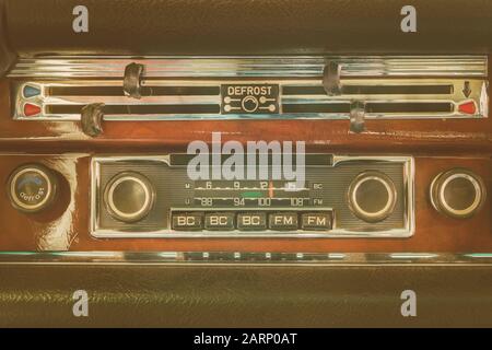 Retro-Design eines alten Armaturenbretts mit 70er Autoradio in einem klassischen Oldtimer Stockfoto