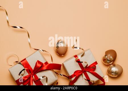 Stilvoller Hintergrund mit goldenen ostereiern, Geschenkschachteln mit Platz für Text. Flache Lage, Draufsicht. Osterkonzept. Stockfoto