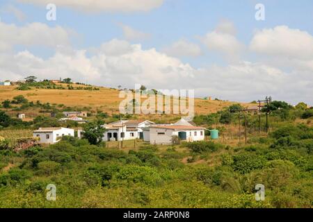 Wohnhäuser im Dorf an der Straße zwischen St. Lucia und Imfolozi-Hluhluwe National Park, KwaZulu Natal, Südafrika. Stockfoto
