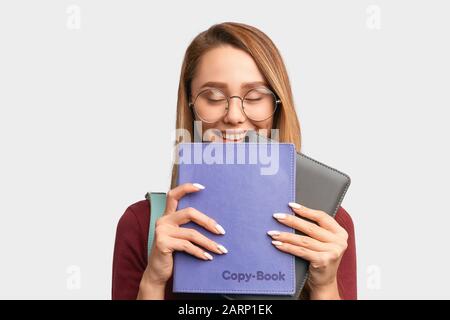 Student versteckt sich hinter Büchern, schließt Augen Lachen Stockfoto