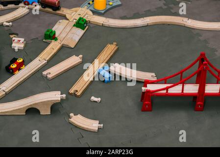 Holzspielzeugeisenbahn. Designerblöcke sind auf dem Boden verstreut. Bildungsspiele für Kinder. Stockfoto