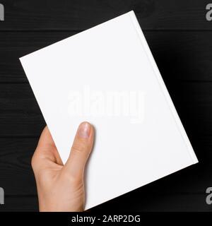 Männer halten geschlossenes Buch mit leerem Cover auf hellem Hintergrund Stockfoto
