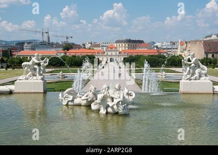 Wien, Österreich - 5. Juni 2019; Statuen in einem Brunnen im Garten von Belvedere, mit dem unteren Schloss Belvedere und der Stadt Wien im Hintergrund Stockfoto