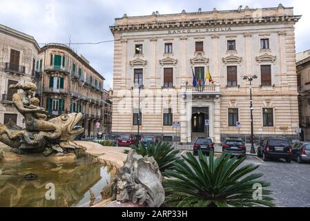 Artemis-Brunnen (auch genannt Diana Fountain) und Banco di Sicilia auf Archimedes Platz (Piazza Archimede) auf der Insel Ortygia, Syrakus, Sizilien, Italien Stockfoto
