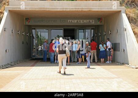 Touristen, die zu Fuß die Eingangstür der Wiege der Menschheit, Maropeng, Gauteng, Südafrika, erreichen. Stockfoto