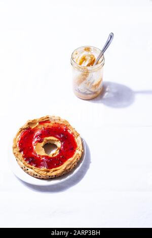 Hausgemachter Bagels mit Naturleo-Nuss-Erdnuss und Cashew cremige Butter und Marmelade auf weißem Hintergrund. Gesundes Frühstücks-Brunch-Konzept Stockfoto