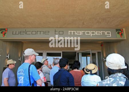 Touristen, die zu Fuß die Eingangstür der Wiege der Menschheit, Maropeng, Gauteng, Südafrika, erreichen. Stockfoto