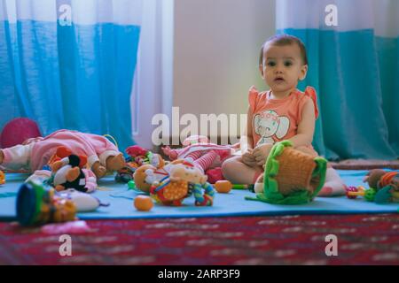 Ein süßes kleines Mädchen, das zu Hause auf dem Boden Spielzeug spielt. Stockfoto