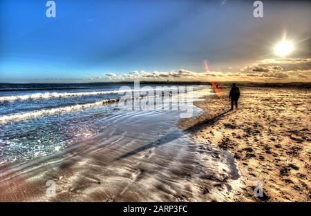 Stadt St Andrews, Schottland. Künstlerische Sicht auf West Sands Beach, an einem kalten Januartag, mit der Stadt St Andrews im fernen Hintergrund. Stockfoto