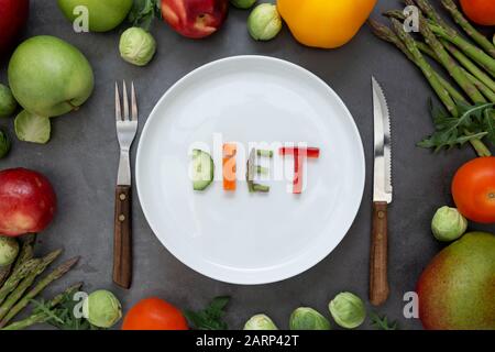 Diät-Konzept. Runder Teller mit Wort - Diät - besteht aus verschiedenen Obst- und Gemüsescheiben mit buntem Obst- und Gemüserahmen. Stockfoto