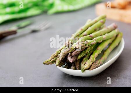 Spargelspeere über dunklem Hintergrund mit Kopierraum schließen. Gesundes, veganes Lebensmittelkonzept. Sauberes Essen. Stockfoto