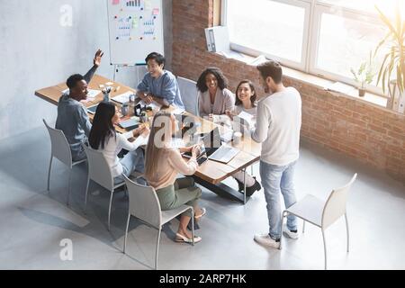 Multiethnische Gruppe von Mitarbeitern, die über Geschäftstreffen diskutieren Stockfoto