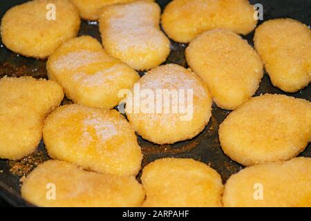 Hühnernuggets werden in einer Pfanne gebraten. Nahaufnahme Stockfoto